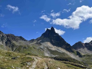 A mountainous landscape with a prominent peak, a clear sky, and a trail leading towards the summit. - Ideal apartment, elevator - 6 guests (Valloire)