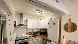 Een moderne keuken met witte kasten, roestvrijstalen apparatuur en een houten aanrecht.