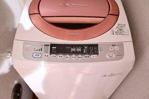 Un lave-linge à technologie Inverter de couleur blanche, doté d’un panneau de commande avec de nombreux boutons et d’un écran numérique.