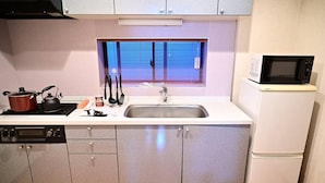 A compact kitchen with a sink, stove, and microwave. - Honmachi 2 Chome (Tokyo)