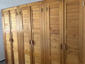 Ein Holzkleiderschrank mit mehreren Türen und Griffen.