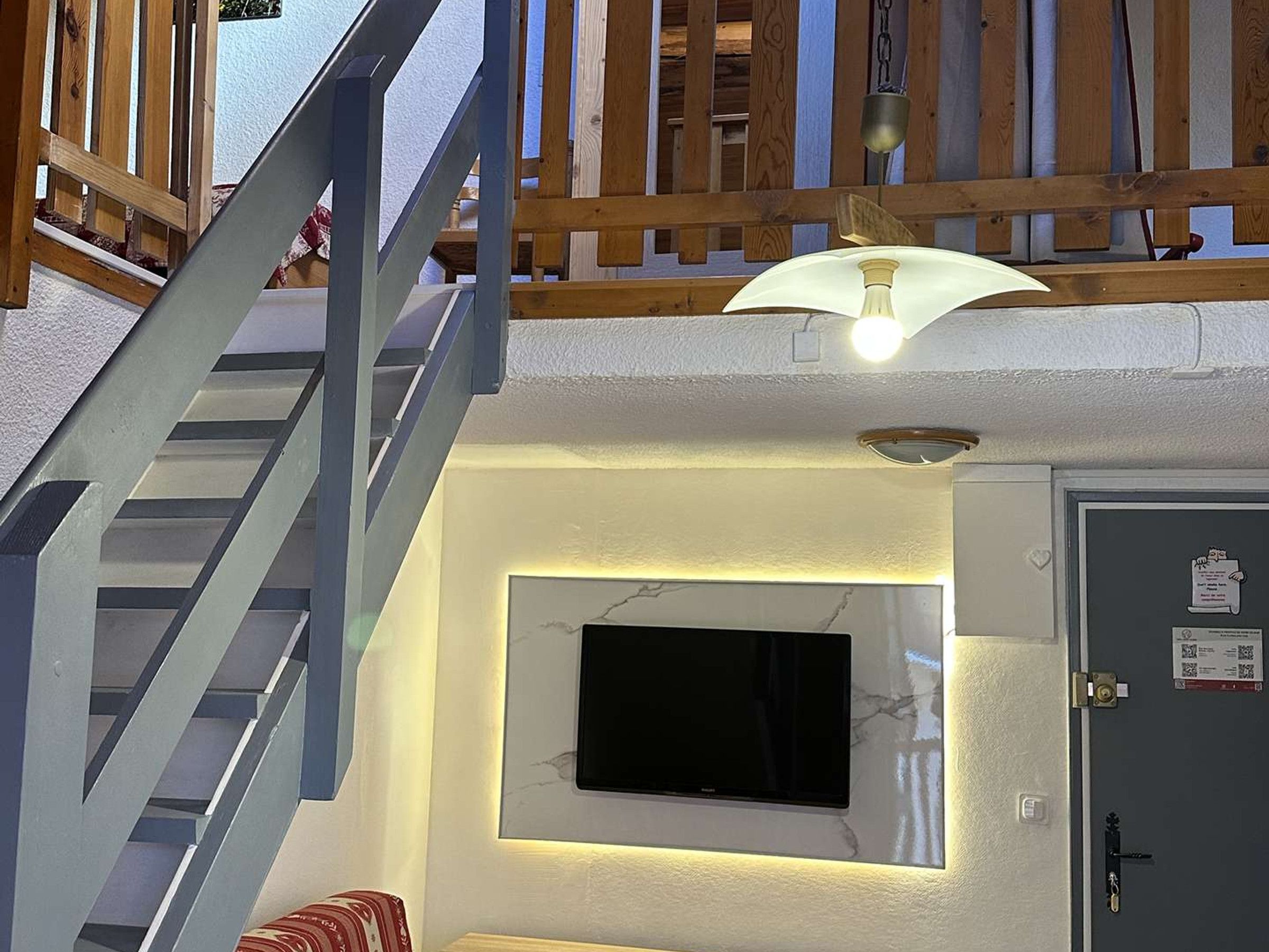 A staircase with a wooden railing leading to a landing.