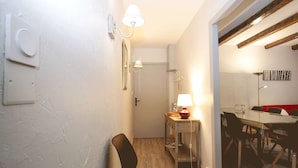 A modern interior with a dining area, a small table with a lamp, and a chair. - Central apartment, pets welcome - 6 guests (Valloire)