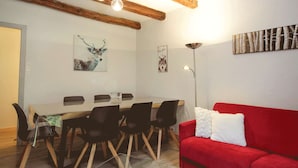 A dining area with a wooden table, black chairs, and a red sofa. - Central apartment, pets welcome - 6 guests (Valloire)