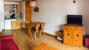 Un espacio habitable pequeño con cocina, comedor y mueble para televisión.