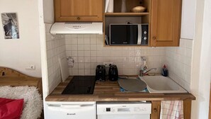 Una piccola cucina attrezzata con forno a microonde, tostapane e lavastoviglie.