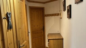 Una porta di legno, un piccolo armadietto e una parete con quadri.