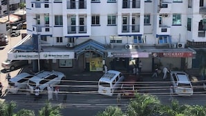 Ett hotell med flera våningar, balkonger, luftkonditionering och en restaurang på markplan.