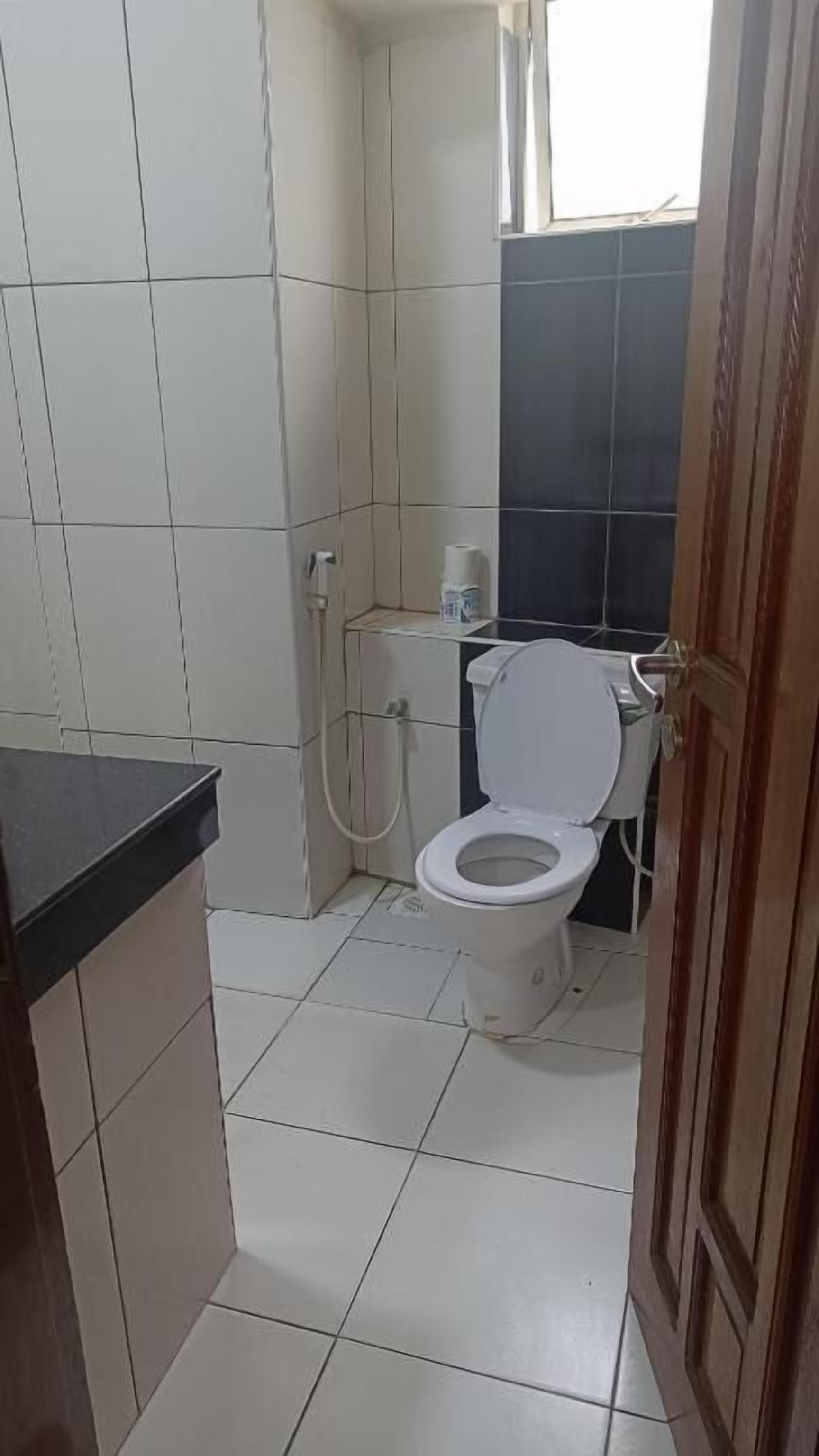A small bathroom with a toilet, a shower, and a sink.