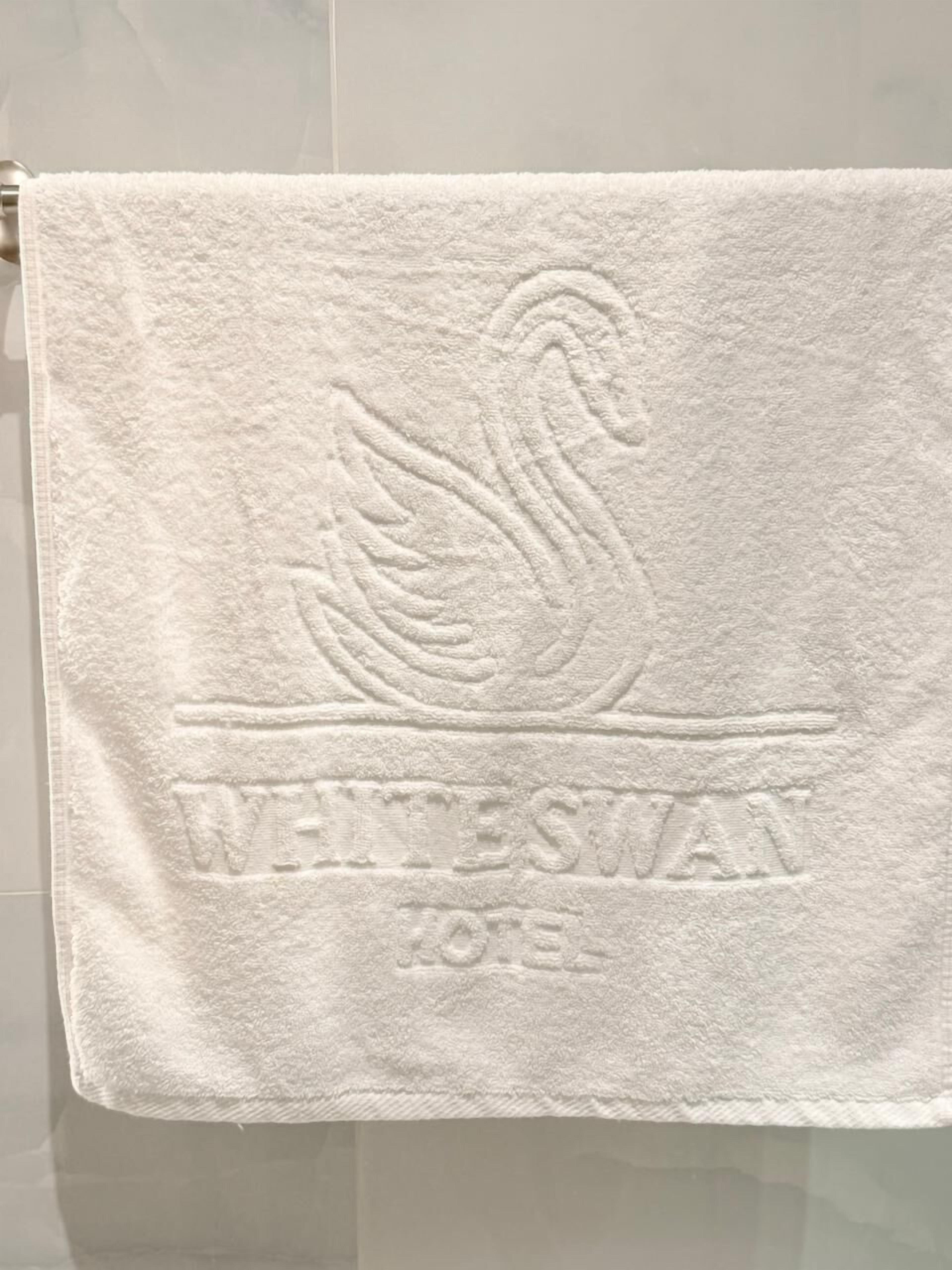 Une serviette ornée d’un cygne et portant en relief l’inscription « WHITESWAN 2013 ».