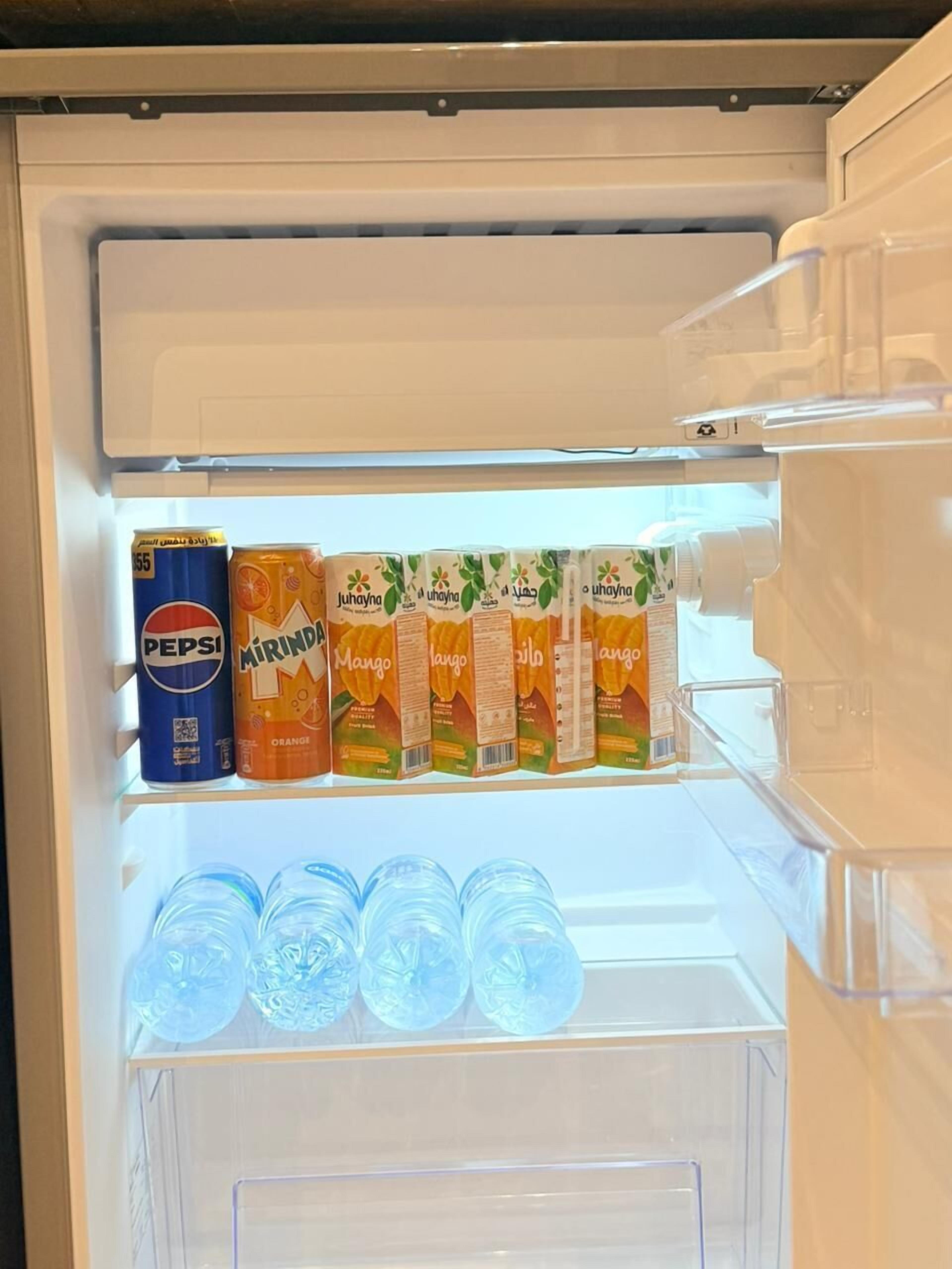 A refrigerator with beverages including Pepsi, Mirinda, and mango juice.