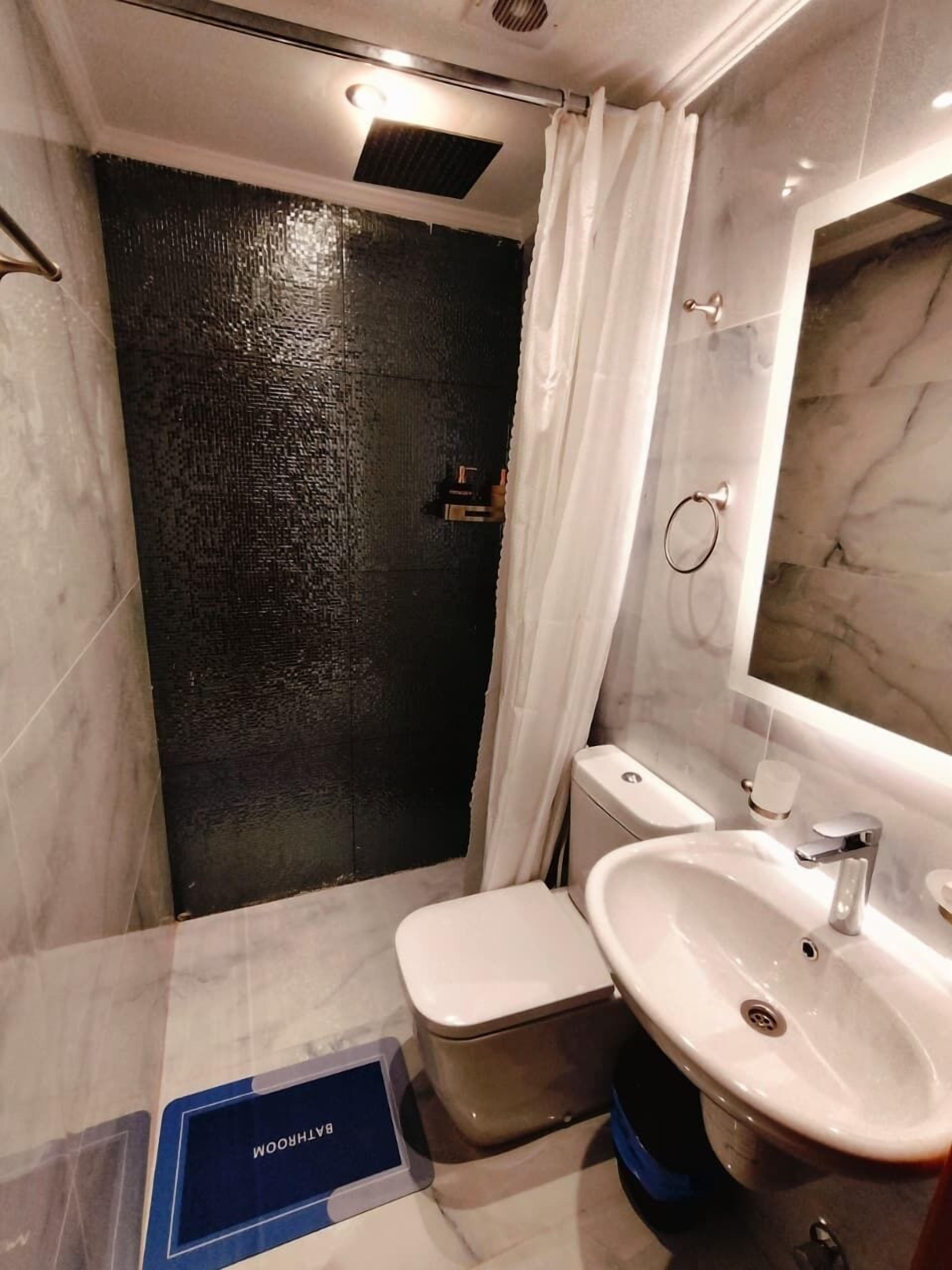 A bathroom with a toilet, sink, and shower.