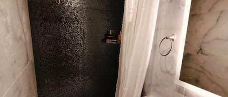 A bathroom with a toilet, sink, and shower.