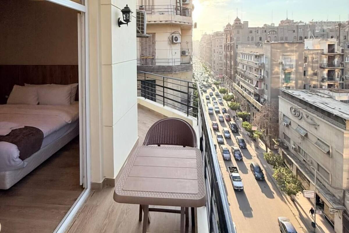 Un balcón con una cama, una mesa y una silla.