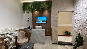A reception area with a TV, wooden panel wall, and seating. - white swan hotel (Cairo)