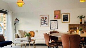 Un espace repas moderne avec une table ronde, des chaises marron et des luminaires suspendus.