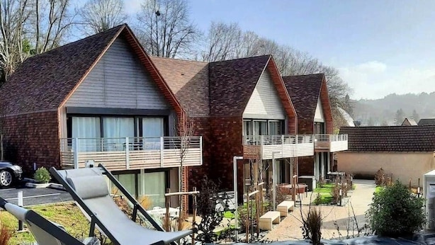A modern building with multiple units, each featuring a balcony and large windows.