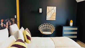 A modern bedroom with a large bed, a chair, a small cabinet, and artwork on the wall. - Le Spicy 2 minutes historical center parking (Sarlat-la-Canéda)