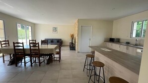 A spacious kitchen with a dining area, a bar, and a view of the outdoors. - House sleeps 6 pool (Sarlat-la-Canéda)
