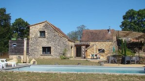 A stone house with a pool, outdoor seating, and a covered patio area. - Atypical pool house in a bucolic setting. (Campagnac-lès-Quercy)