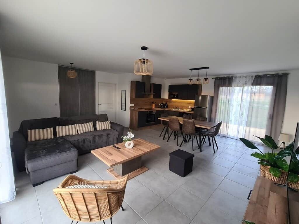 A modern living room with a sofa, coffee table, and dining area.