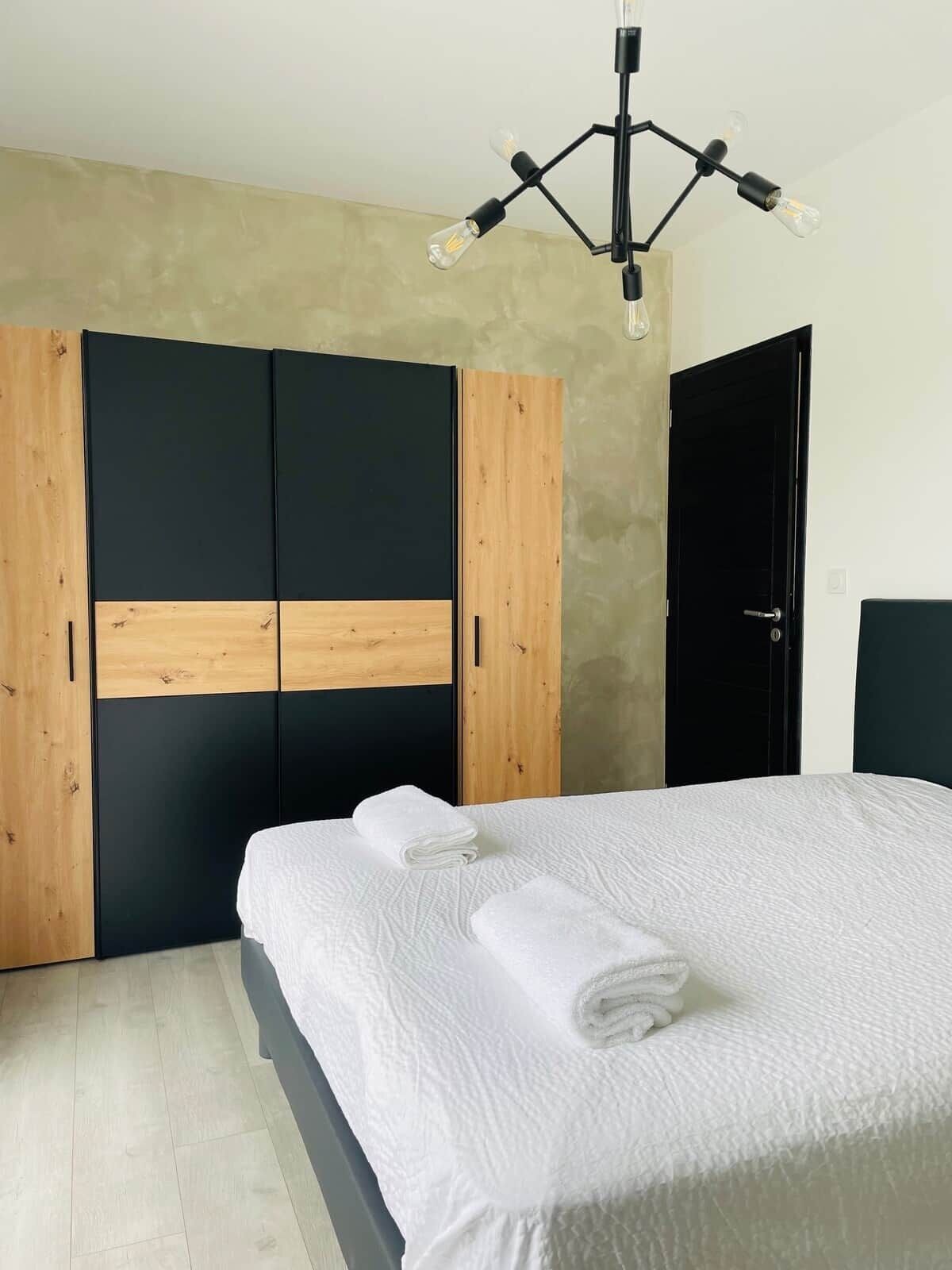 A bedroom with a bed, a wardrobe, and a door.