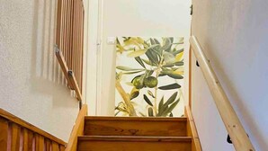 A wooden staircase with a handrail, leading to a door with a plant visible through it. - Villa*Piscine*Proche Sarlat (Proissans)