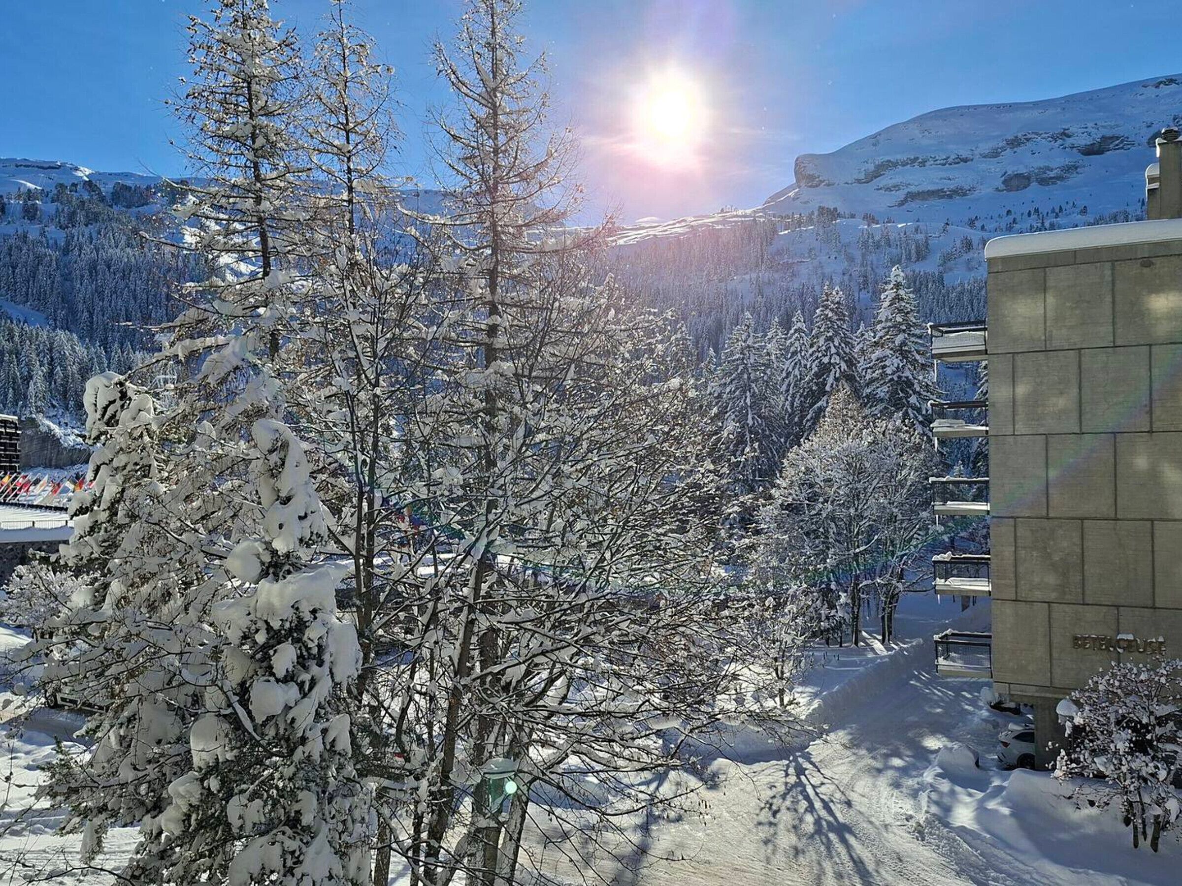 Un paisaje nevado con un edificio con la leyenda 'BETHOLLE' y un cielo despejado.