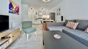 Una sala de estar moderna con televisor, sofá y mesa de centro.