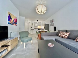A modern living room with a TV, sofa, and coffee table. - Modern apartment between city and cable car - 6 guests (Briançon)