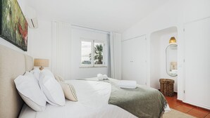 A hotel room with a bed, a window with a view, a lamp, and a mirror. - Villa Óscar 4-bedroom with AC in lovely Lagos (Lagos)