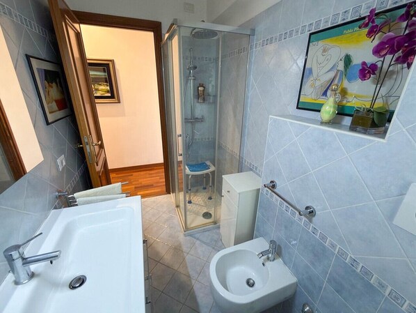 A bathroom with a bathtub, a sink, a bidet, and a shower enclosure. - Naif - a beautiful apartment in Rome (Roma)