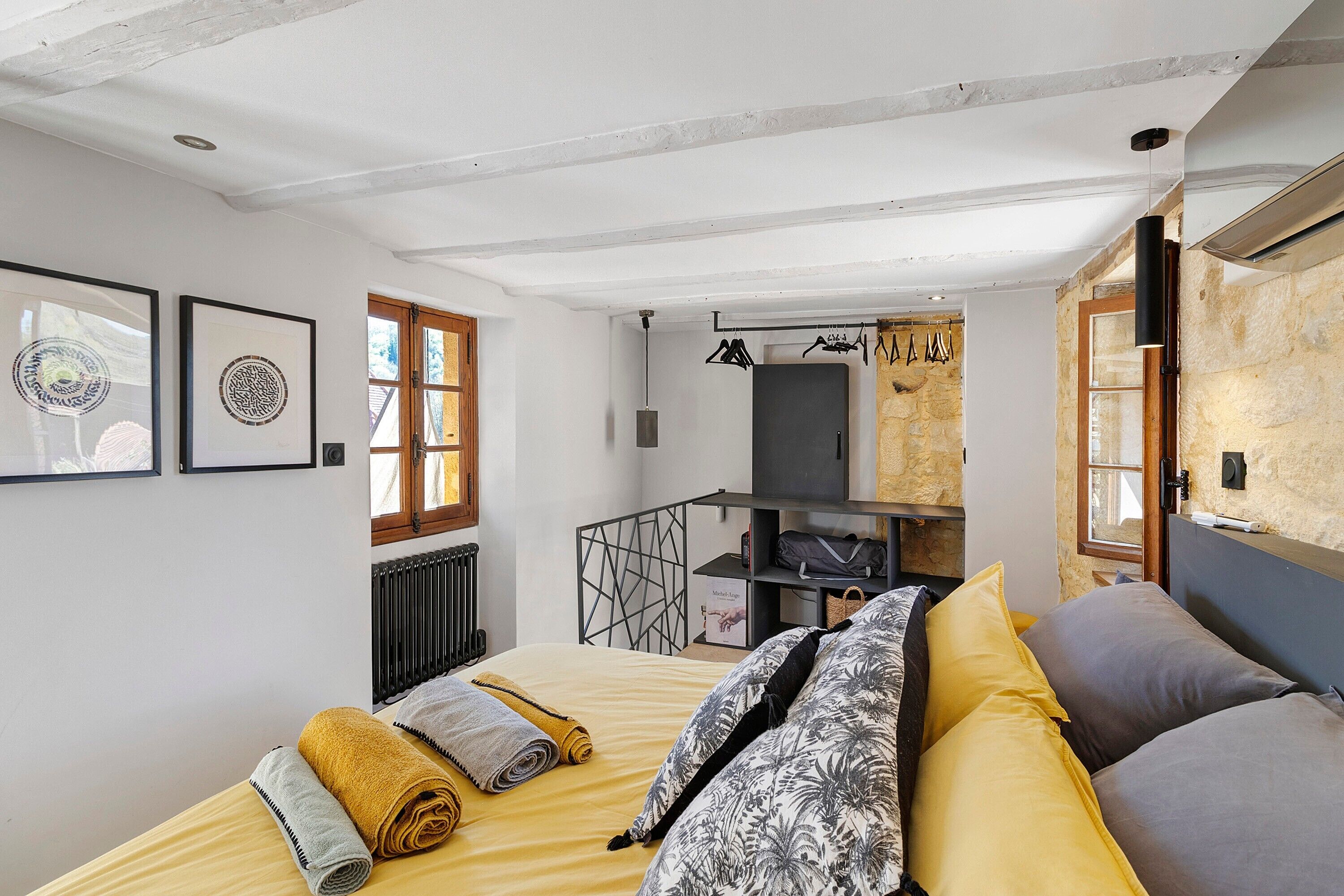 Un dormitorio con cama, radiador, ventana y puerta.