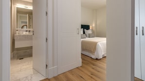 Een slaapkamer met een bed, nachtkastje en spiegel.