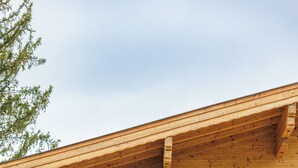 Ein Holzbalkon mit Fenstern und einer Lampe.