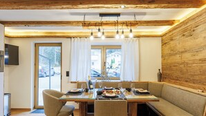 A dining area with a wooden table, chairs, and a bench. - Die Steinberg Chalets (St. Ulrich Am Pillersee)