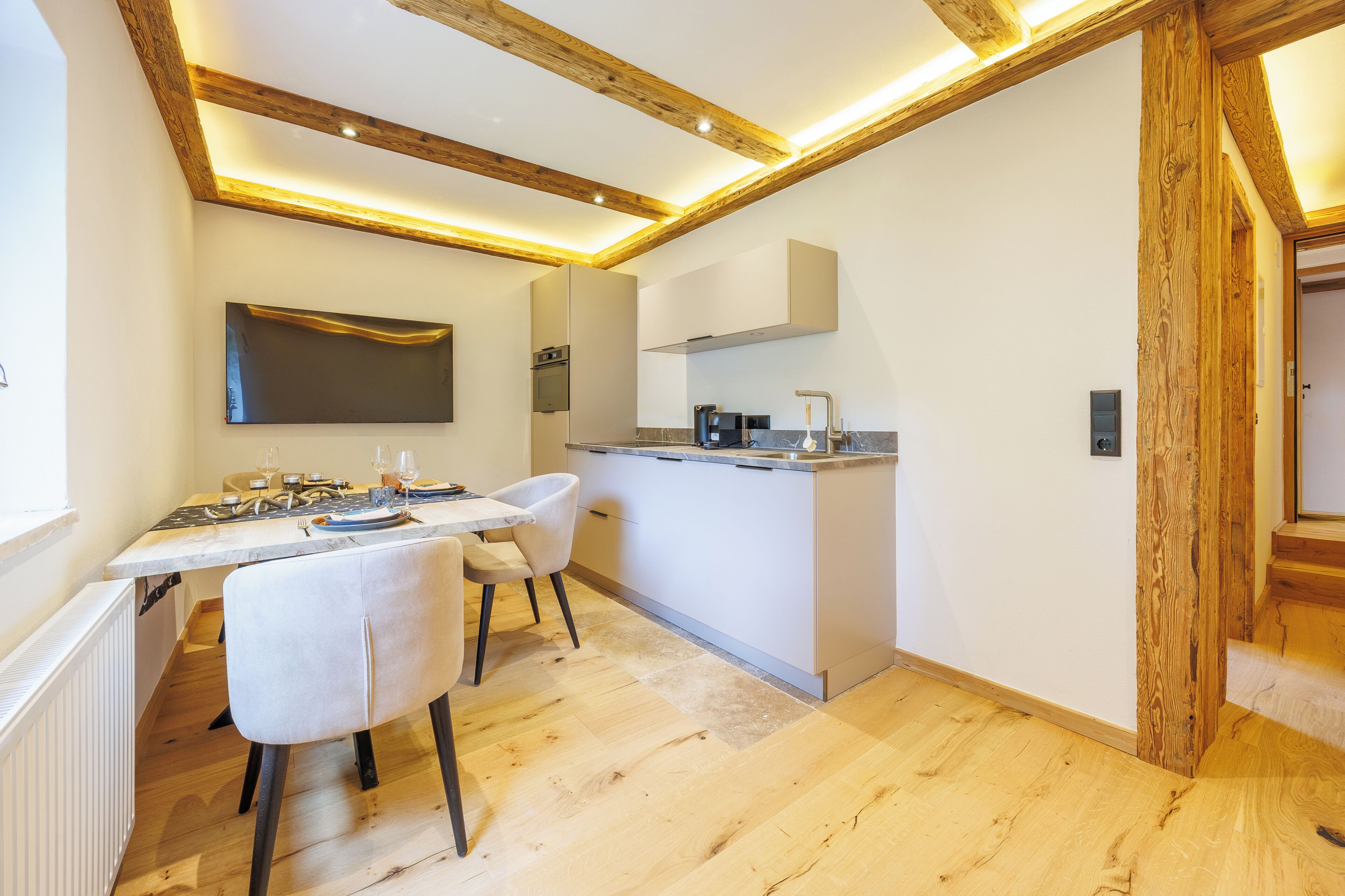 A modern kitchen with a built-in oven, a coffee machine, and a sink.