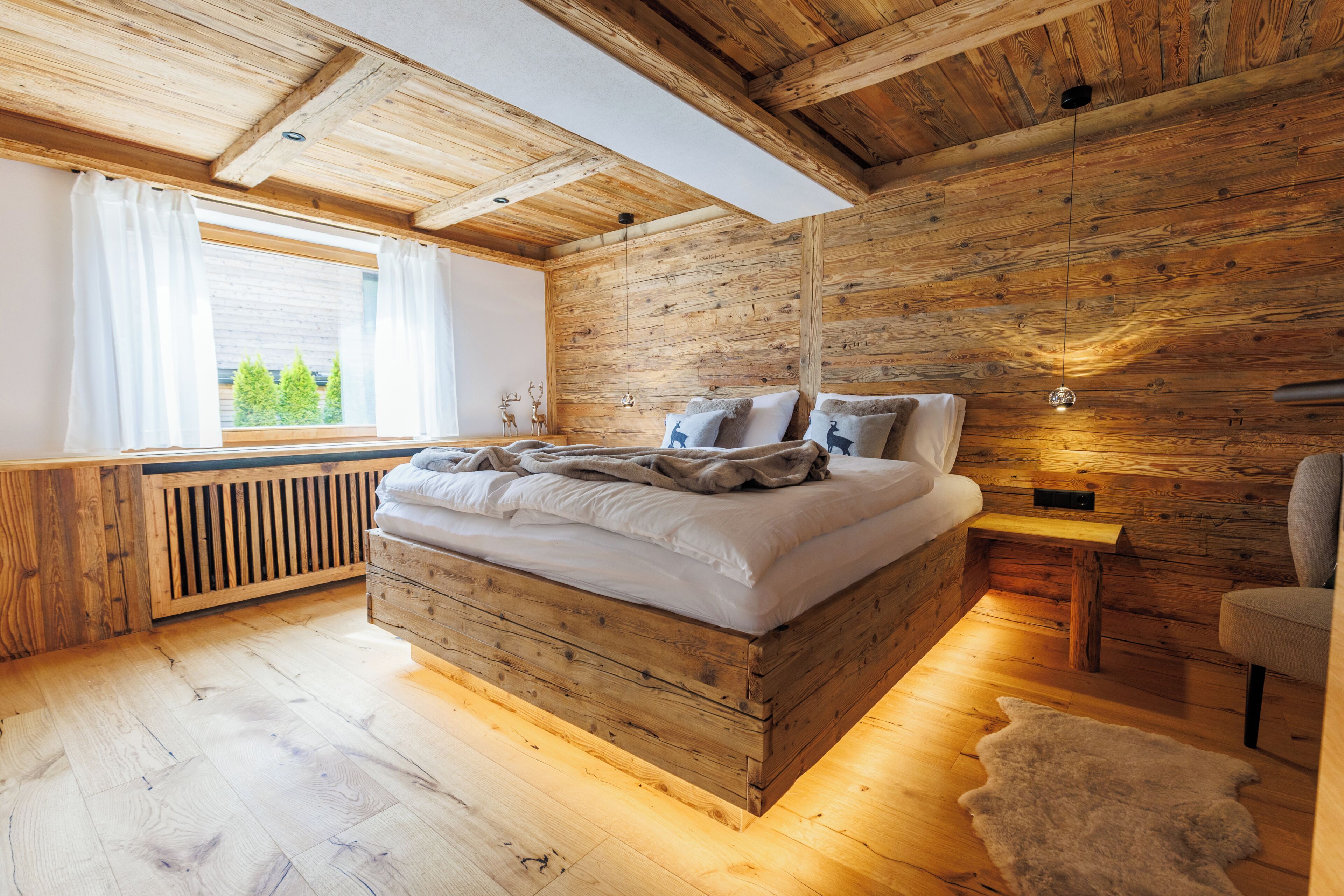 Une chambre dans une cabane en bois, avec un lit, une fenêtre et un radiateur.
