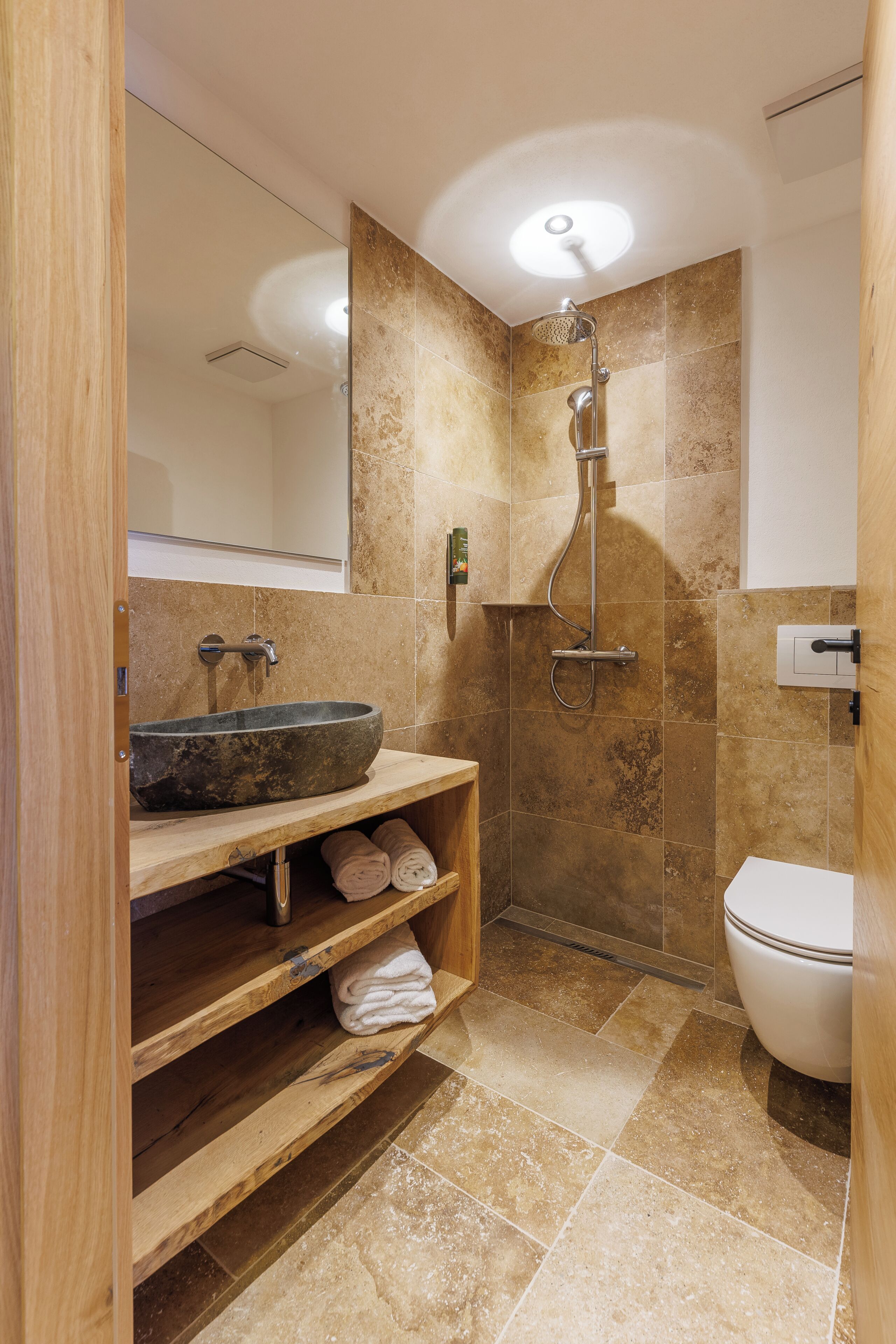 A bathroom with a large sink, shower, and toilet.