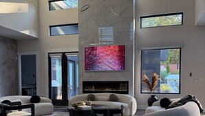 A spacious living room with a fireplace, large windows, and modern furniture. - Gorgeous Modern Compound w/ private resort backyard & full outdoor kitchen (Decatur)