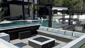 A modern outdoor pool area with a built-in fire pit and seating. - Gorgeous Modern Compound w/ private resort backyard & full outdoor kitchen (Decatur)