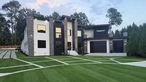 A modern two-story house with a garage, a well-maintained lawn, and a driveway. - Gorgeous Modern Compound w/ private resort backyard & full outdoor kitchen (Decatur)