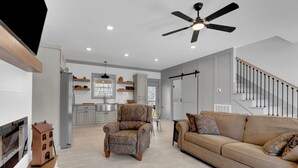 A spacious living room with a large sofa, a patterned armchair, and a wooden coffee table. A ceiling fan and recessed lighting are visible. - Cozy Modern Farmhouse near Normandy Lake (Normandy)