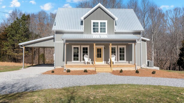 A two-story house with a covered porch, a front door, and a small front yard. - Cozy Modern Farmhouse near Normandy Lake (Normandy)