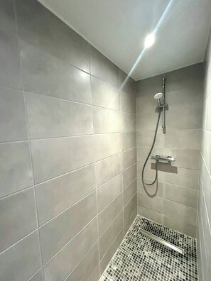 Een douche, een haardroger, handdoeken, toiletpapier