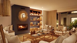 A modern living room with a fireplace, comfortable seating, and decorative shelves. - Walkers Beach (Plettenberg Bay)