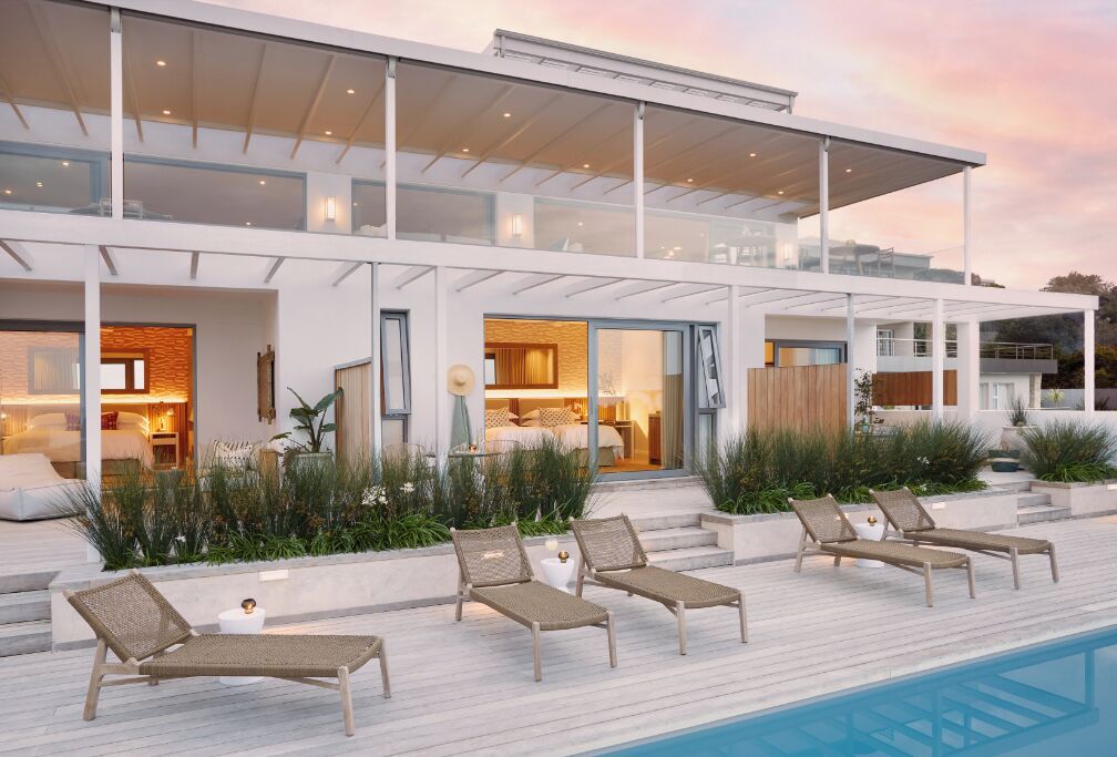 A modern house with a pool, lounge chairs, and a well-maintained garden.