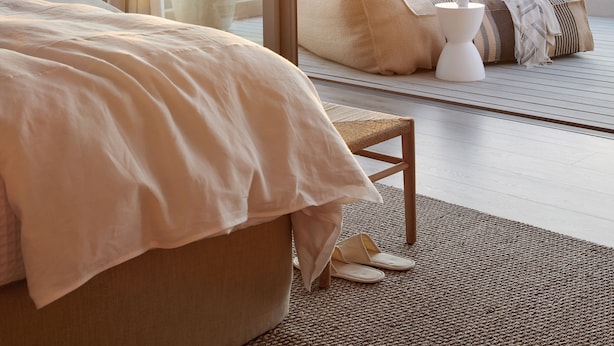 A bedroom with a large bed, a view of the sea, and a balcony with potted plants. - Walkers Beach (Plettenberg Bay)