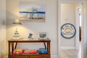 A hallway with a table displaying a lamp, a framed picture, and a small sculpture. A wall sign reads 'The Blue Pearl Long Beach, MS.' - Cute Cottage Near Beaches - sleeps 8 (Long Beach)