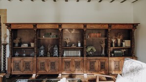 A wooden bookcase with shelves, a patterned cushion, and a lamp. - Hotel Boutique Palacio de Caranceja (Reocín)